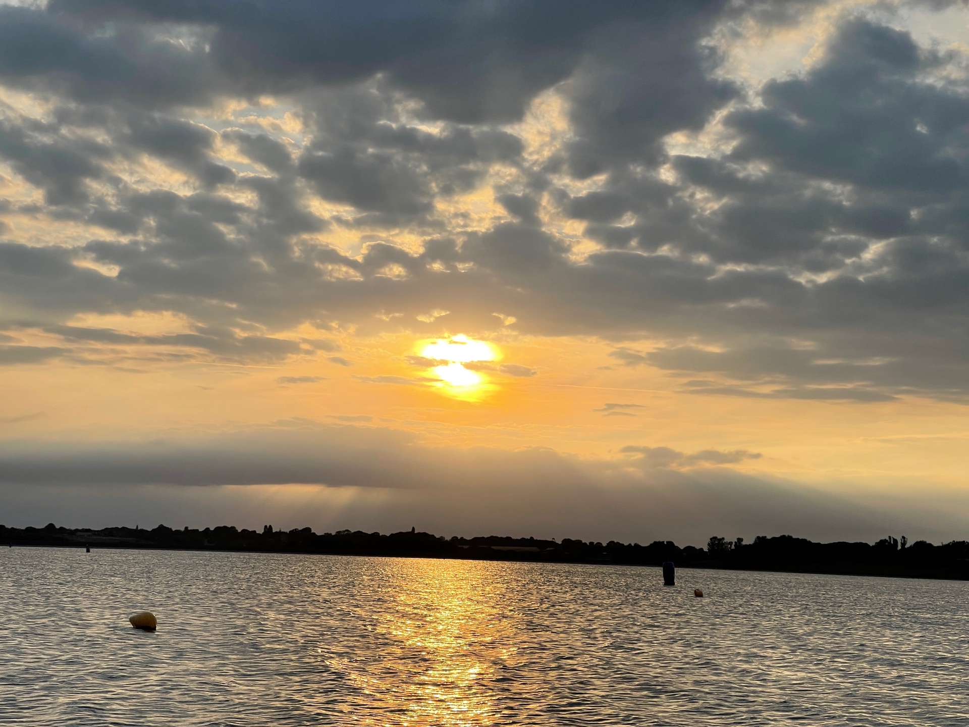 The sun setting in gold over a calm reservoir